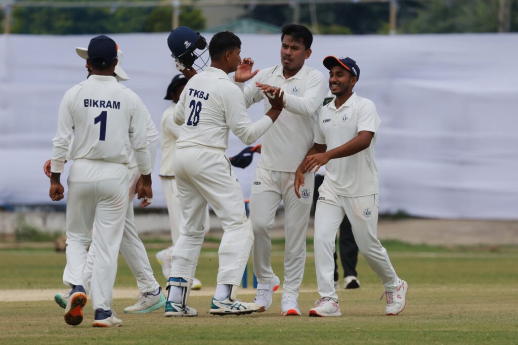 Tripura's MB Mura Singh (second right) is congratulated on taking a wicket